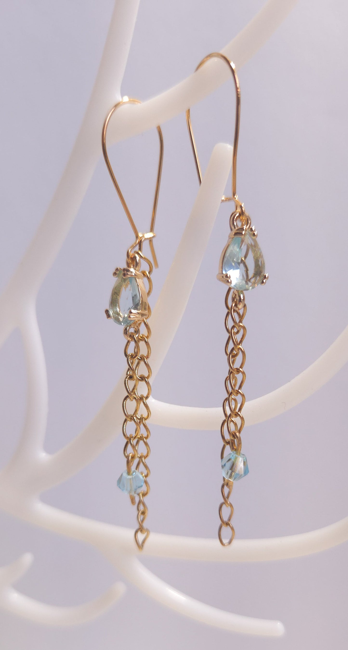 Détail des chaînes fines dorées des boucles Nébuleuse, 7 cm, verre bleu clair