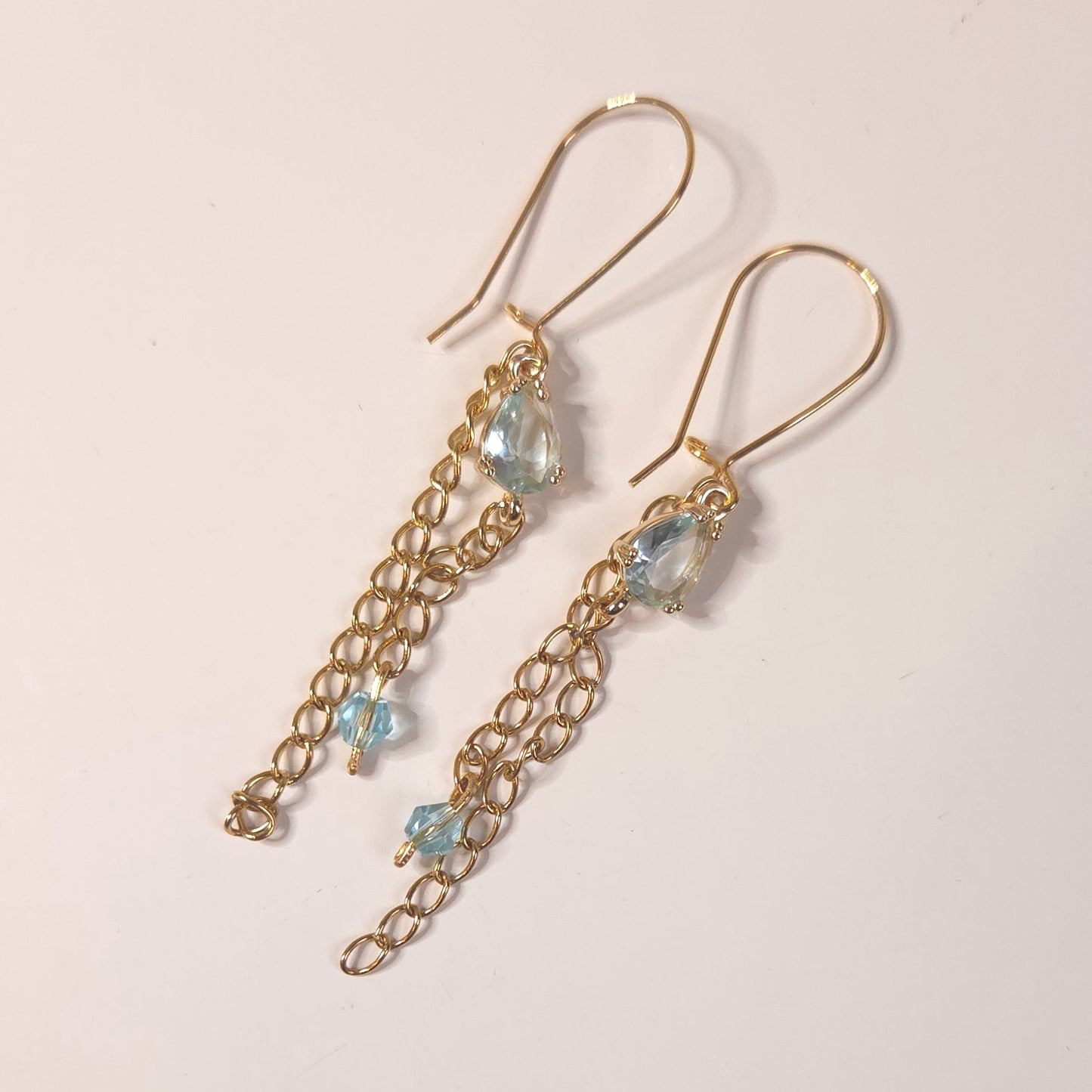 Gros plan sur pendentifs en verre bleu clair des boucles d’oreilles Nébuleuse